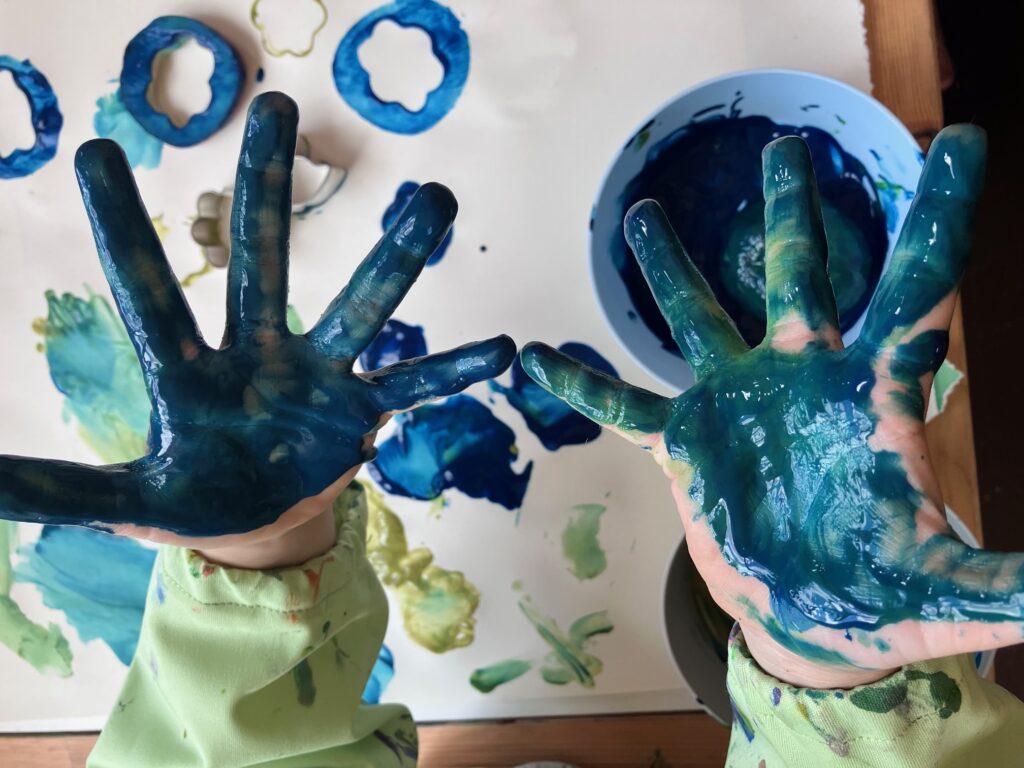 Summer Preschool Play Week I: Bunny Theme. Shows a child's hands covered in blue paint.